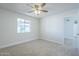 Bright bedroom with neutral carpet, ceiling fan, and a large window at 1450 E Topeka Dr, Phoenix, AZ 85024