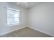 Bright bedroom with neutral carpet, ceiling fan, and large window at 1450 E Topeka Dr, Phoenix, AZ 85024