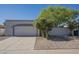 Beige single story home with a two-car garage, desert landscaping and blue sky at 1450 E Topeka Dr, Phoenix, AZ 85024