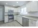 Bright kitchen with white cabinets, stainless steel appliances, and light countertops at 1450 E Topeka Dr, Phoenix, AZ 85024