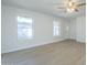 Bright living room with light wood floors, ceiling fan, and two large windows at 1450 E Topeka Dr, Phoenix, AZ 85024