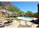 Backyard featuring stone patio, desert landscaping, grassy area, pool, and scenic mountain views at 14833 S 14Th Pl, Phoenix, AZ 85048