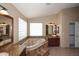 Luxurious bathroom showcasing a soaking tub, granite countertops, dual sinks and decorative tile floors at 14833 S 14Th Pl, Phoenix, AZ 85048