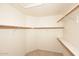 Walk-in closet featuring built-in wooden shelves for storage and organization, with carpeted flooring at 14833 S 14Th Pl, Phoenix, AZ 85048