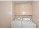 Functional laundry room featuring a washer, dryer, and convenient overhead storage cabinets at 14833 S 14Th Pl, Phoenix, AZ 85048