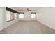 Large living room with neutral carpet, ceiling fan, and many bright windows at 14833 S 14Th Pl, Phoenix, AZ 85048