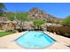 Backyard pool featuring desert landscaping, and mountain views, surrounded by lush trees and a fence at 14833 S 14Th Pl, Phoenix, AZ 85048