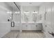Modern bathroom with dual sinks, a glass-enclosed shower, and neutral decor at 15620 W Georgia Dr, Surprise, AZ 85379
