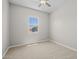 A simple bedroom with gray walls, carpeted floors, a window, and a ceiling fan at 15620 W Georgia Dr, Surprise, AZ 85379