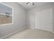 A simple bedroom with gray walls, carpeted floors, a window, and a closet with sliding doors at 15620 W Georgia Dr, Surprise, AZ 85379