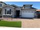Beautiful single-story home with a manicured lawn, stone accents, and a spacious two-car garage at 15620 W Georgia Dr, Surprise, AZ 85379