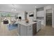 Open kitchen with island featuring dishwasher, white cabinets, and dining area beyond at 15620 W Georgia Dr, Surprise, AZ 85379
