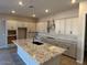 Bright kitchen featuring an island, granite countertops, and stainless steel appliances at 15620 W Georgia Dr, Surprise, AZ 85379