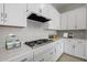 Well-appointed kitchen with quartz counters, gas cooktop, stainless hood and white cabinetry at 15620 W Georgia Dr, Surprise, AZ 85379