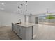 Bright kitchen features an island with seating, stainless appliances, granite countertops, and open layout at 15620 W Georgia Dr, Surprise, AZ 85379
