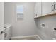 This laundry room features a window and upper and lower white cabinets at 15620 W Georgia Dr, Surprise, AZ 85379