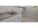 The laundry room has ample counter space with white cabinetry and modern flooring at 15620 W Georgia Dr, Surprise, AZ 85379