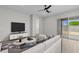 Bright living room with hardwood floors, a ceiling fan, sliding glass doors, and modern furniture at 15620 W Georgia Dr, Surprise, AZ 85379