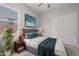 A bedroom with a large bed, two side tables, houseplant, and a window letting in natural light at 15620 W Georgia Dr, Surprise, AZ 85379