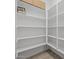 A walk-in pantry with multiple shelves for storage and a light-colored tile floor at 15620 W Georgia Dr, Surprise, AZ 85379