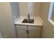 Small sink vanity featuring marble countertop and white shaker cabinets at 15620 W Georgia Dr, Surprise, AZ 85379