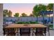 Inviting backyard with modern patio furniture, fire pit, pergola, and manicured landscaping at 15695 W Christy Dr, Surprise, AZ 85379