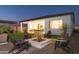 Spacious backyard with covered patio, outdoor dining, custom pergola, stylish seating, and cozy fire pit at 15695 W Christy Dr, Surprise, AZ 85379