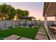 A spacious backyard features manicured lawn, modern patio furniture, and a pergola for outdoor living at 15695 W Christy Dr, Surprise, AZ 85379