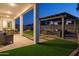 Expansive backyard with covered patio, outdoor dining, custom pergola, stylish seating, and lush artificial turf at 15695 W Christy Dr, Surprise, AZ 85379