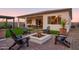 Backyard features a fire pit, outdoor dining area, lush lawn and a covered patio at 15695 W Christy Dr, Surprise, AZ 85379