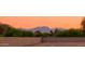 Desert backyard view featuring a block wall and mountain backdrop at sunset at 15695 W Christy Dr, Surprise, AZ 85379