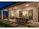 Spacious backyard featuring a covered patio, outdoor dining, lush turf, fire pit, and stylish seating areas at 15695 W Christy Dr, Surprise, AZ 85379