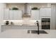 A modern kitchen boasts stainless steel appliances, quartz countertops, and bright white cabinets at 15695 W Christy Dr, Surprise, AZ 85379