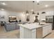 Modern kitchen island with quartz countertops and stainless steel appliances open to the adjacent living area at 15695 W Christy Dr, Surprise, AZ 85379