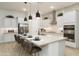 Beautiful kitchen with sleek white cabinets, stainless steel appliances, and a large island with seating for casual dining at 15695 W Christy Dr, Surprise, AZ 85379