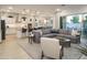 Spacious living room with gray sectional, kitchen view, and sliding glass doors to the outside patio area and modern furnishings at 15695 W Christy Dr, Surprise, AZ 85379