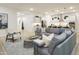 Open-concept living area with a gray sectional sofa that is open to the kitchen with an island and modern countertops at 15695 W Christy Dr, Surprise, AZ 85379