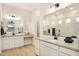 A bright main bathroom with double sinks, quartz countertops, framed mirror, and a walk-in shower at 15695 W Christy Dr, Surprise, AZ 85379