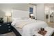 Comfortable main bedroom with a white upholstered headboard, bench, and soft, cozy neutral accents at 15695 W Christy Dr, Surprise, AZ 85379