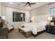 A spacious main bedroom featuring large windows with natural light, a ceiling fan and neutral decor at 15695 W Christy Dr, Surprise, AZ 85379