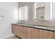 Modern bathroom featuring a double sink vanity, lighted mirrors, and tiled walls at 19355 N 73Rd Way # 4002, Scottsdale, AZ 85255