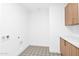 Bright laundry room featuring stylish patterned floors, upper and lower cabinets, and modern fixtures at 19355 N 73Rd Way # 4002, Scottsdale, AZ 85255