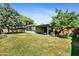 Large backyard featuring mature trees and covered patio at 1941 E Hazelwood St, Phoenix, AZ 85016