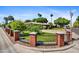 Street view of a beautiful home with lush landscaping, a brick fence, and mature palm trees at 1941 E Hazelwood St, Phoenix, AZ 85016