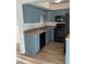 This galley kitchen features blue cabinets, black appliances, and light countertops at 2121 W Royal Palm Rd # 2049, Phoenix, AZ 85021