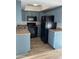This kitchen features blue cabinets, laminate countertops and black appliances at 2121 W Royal Palm Rd # 2049, Phoenix, AZ 85021