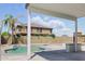 An attractive backyard featuring a covered patio, a pool, desert landscaping, and outdoor kitchen area at 23214 N 106Th Ave, Peoria, AZ 85383