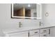 Bright bathroom featuring double sinks, quartz counters, sleek white cabinets, and modern gold fixtures at 23214 N 106Th Ave, Peoria, AZ 85383