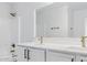 Clean bathroom featuring double sinks, quartz counters, sleek white cabinets, and modern gold fixtures at 23214 N 106Th Ave, Peoria, AZ 85383