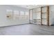 Open concept living room with light gray floors, rock accent wall, and large windows with natural light at 23214 N 106Th Ave, Peoria, AZ 85383